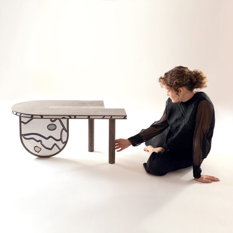 Beautiful model contemplating the minimalist side table Sourire decorated with Talismane textile by Hermes luxury furniture decor line Metaphores Paris